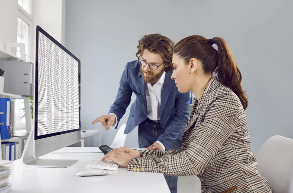 Two Accountants Working In Office And Looking At Business Spread